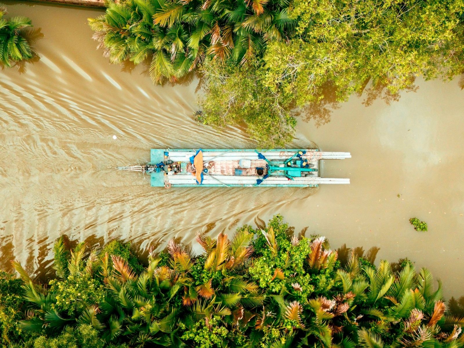 Itinerary Vietnam Vegan Travel Bamboo boat gliding along the river in Mekong Delta, Vietnam