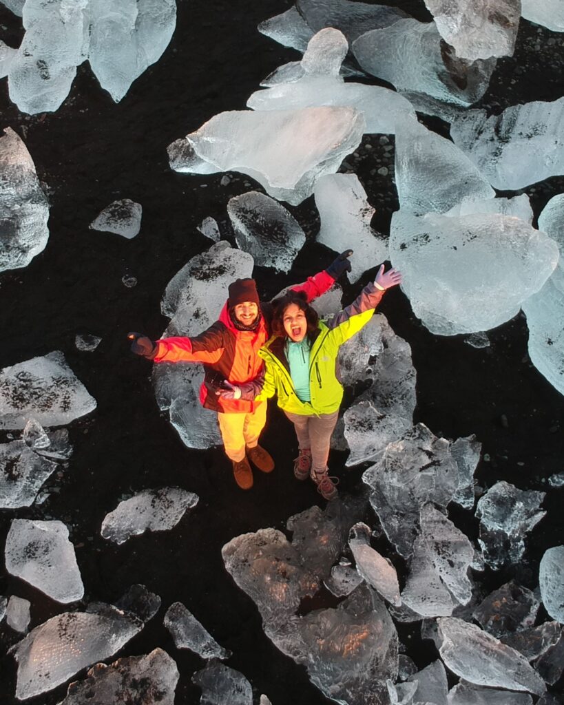 Travellers looking up from Diamond Beach in Iceland