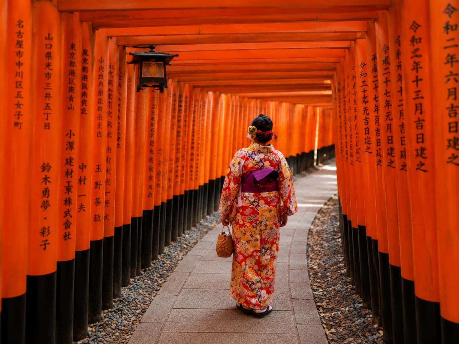 Traveller walking through the Fushimi Inari torii gates in Kyoto