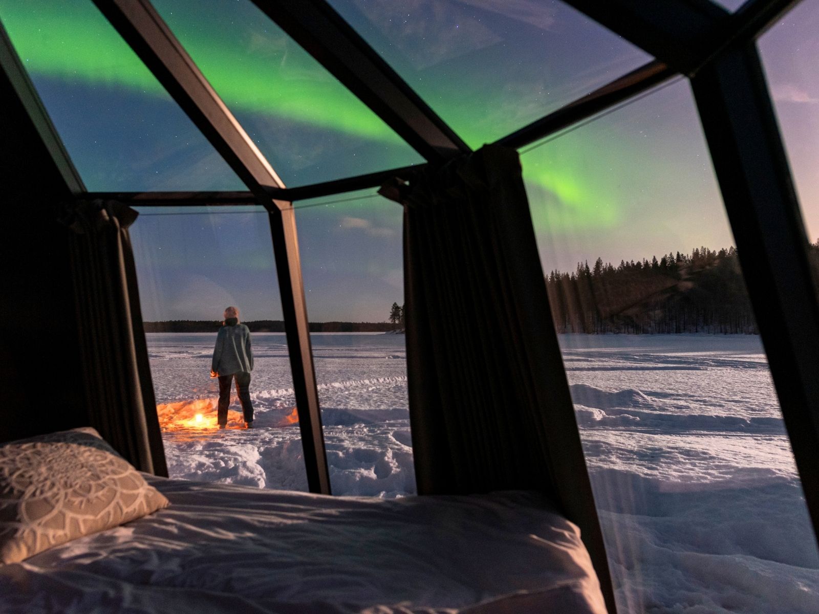 Glass igloo beneath the Northern Lights in Finnish Lapland