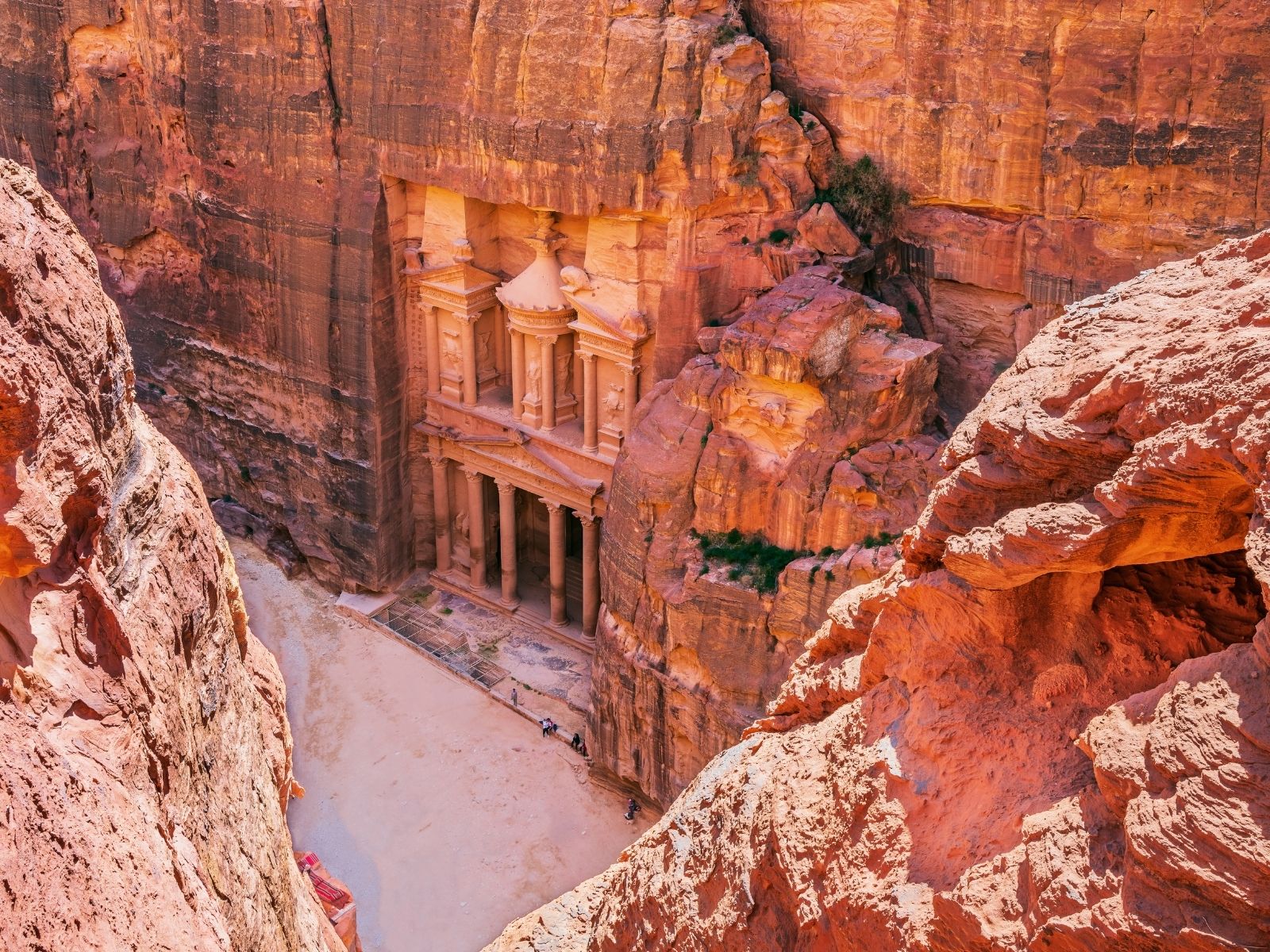 Treasury of Petra carved into red sandstone cliffs in Jordan
