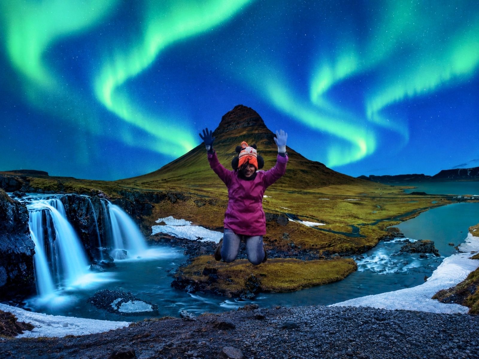 Traveller beneath the Northern Lights at Kirkjufell Mountain and Kirkjufellsfoss, Iceland